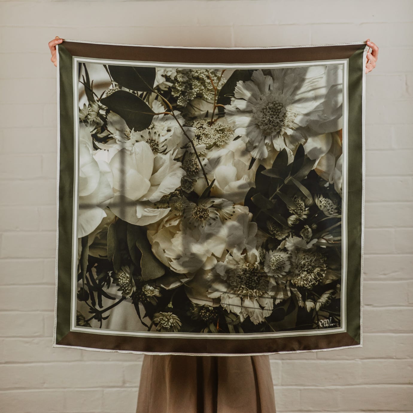 Briar, a silk scarf printed with a close view of white peonies, scabiosa and astrantia among dark foliage, framed in deep olive with a fine ivory line.